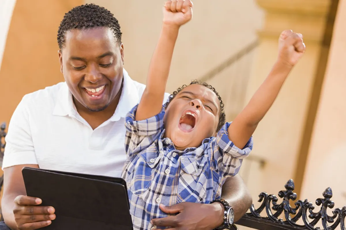 Image of father and child looking at a tablet together