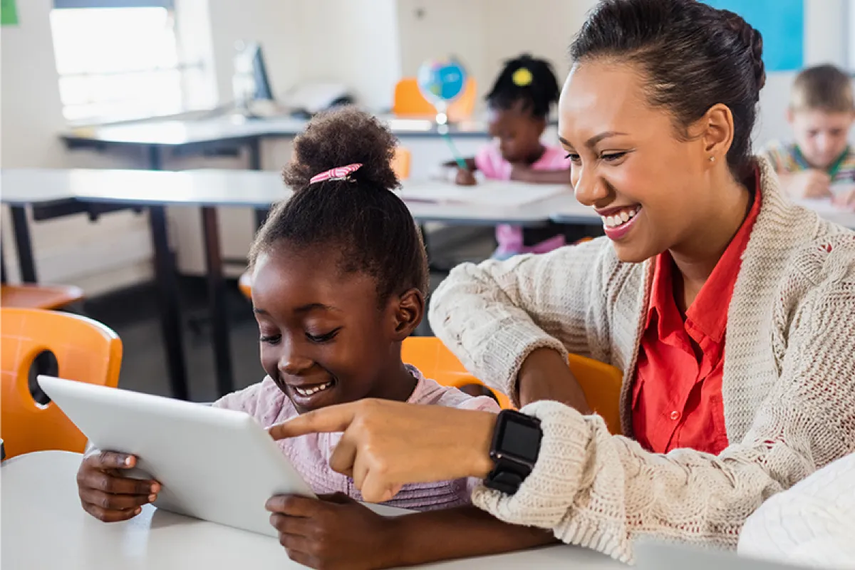 Image of teacher and student looking at a tablet together